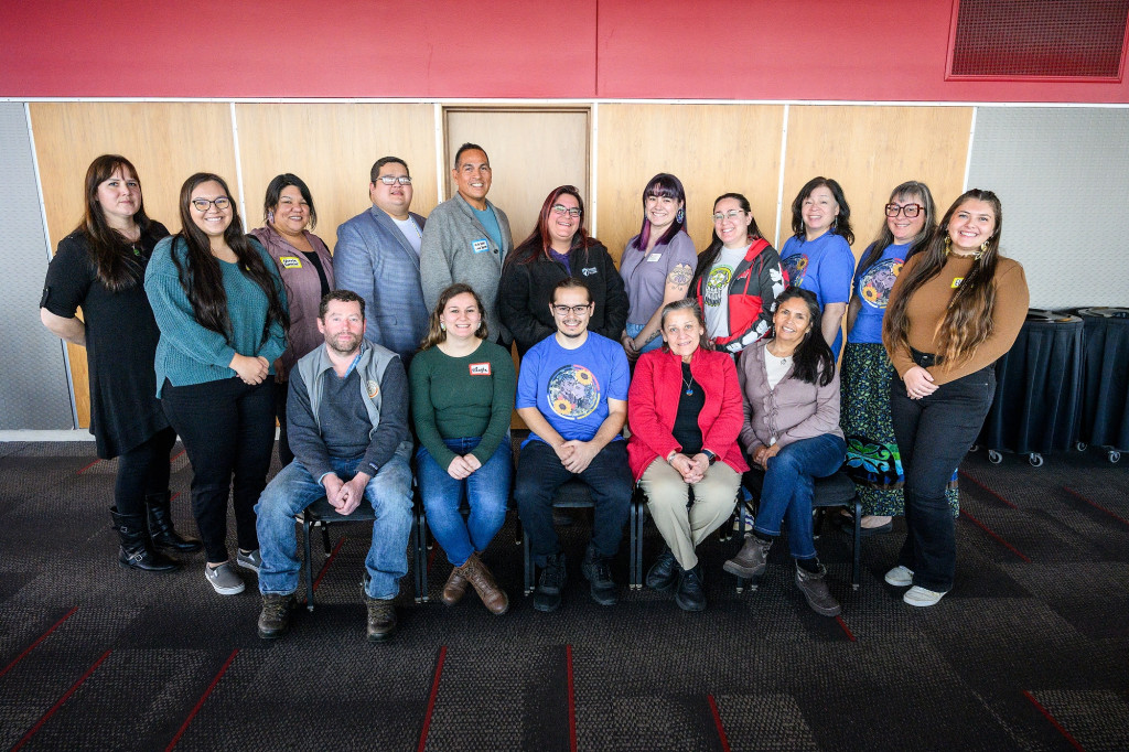 A group of UW alumni pose together in two rows.