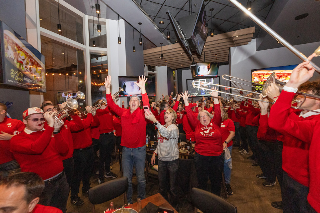 People wearing red cheer and dance.