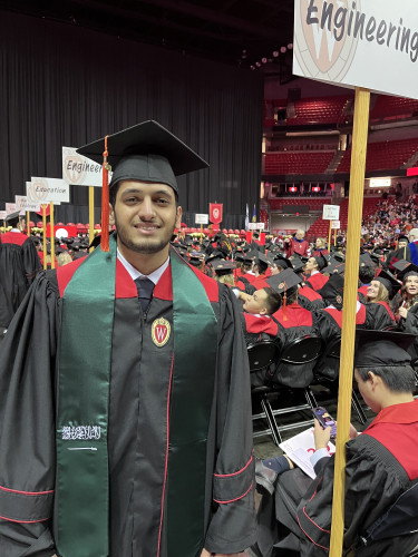 A man wears graduation robes.