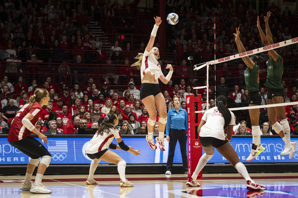 A woman strikes a volleyball.