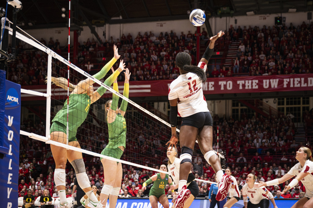 A woman hits a volleyball.