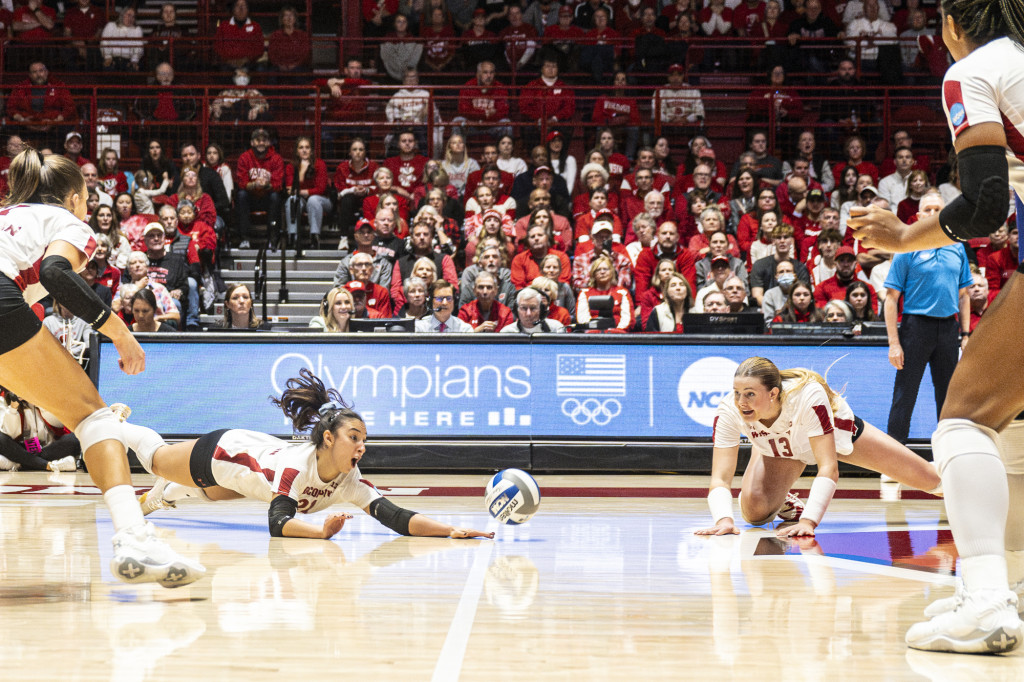 A volleyball player dives for a ball.