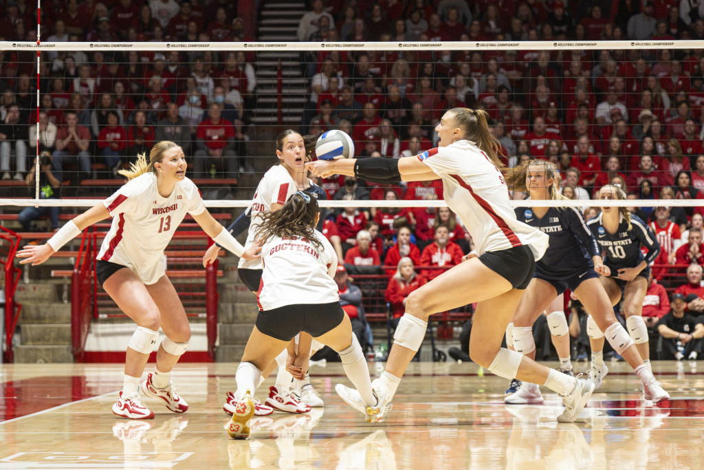 A woman reaches for a volleyball; other players watch.