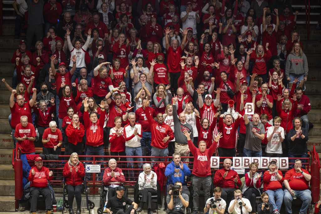 A red-clad crowd of people in stands cheer.