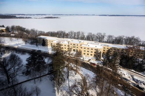 A frozen lake is pictured, with buildings in the foreground.