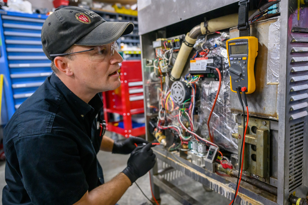 A man examines some machinery.