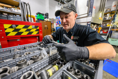 A man rummages through a tool box.