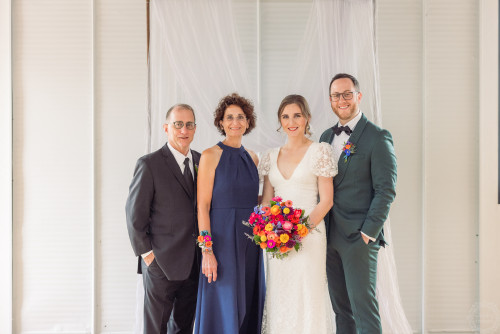 A wedding day photo of newly married Rachel and Matthew Lupini standing to the right of Rachel's parents, Doug and Marilyn Olk.