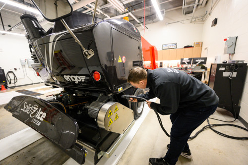 A man plugs in a large piece of machinery.