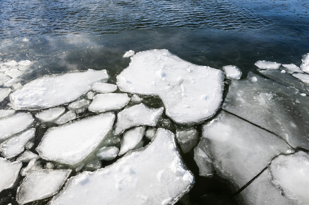 Ice with gaps showing water on a lake's surface.