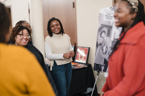 Event attendees gather around an archival poster, participating in an engaging discussion.