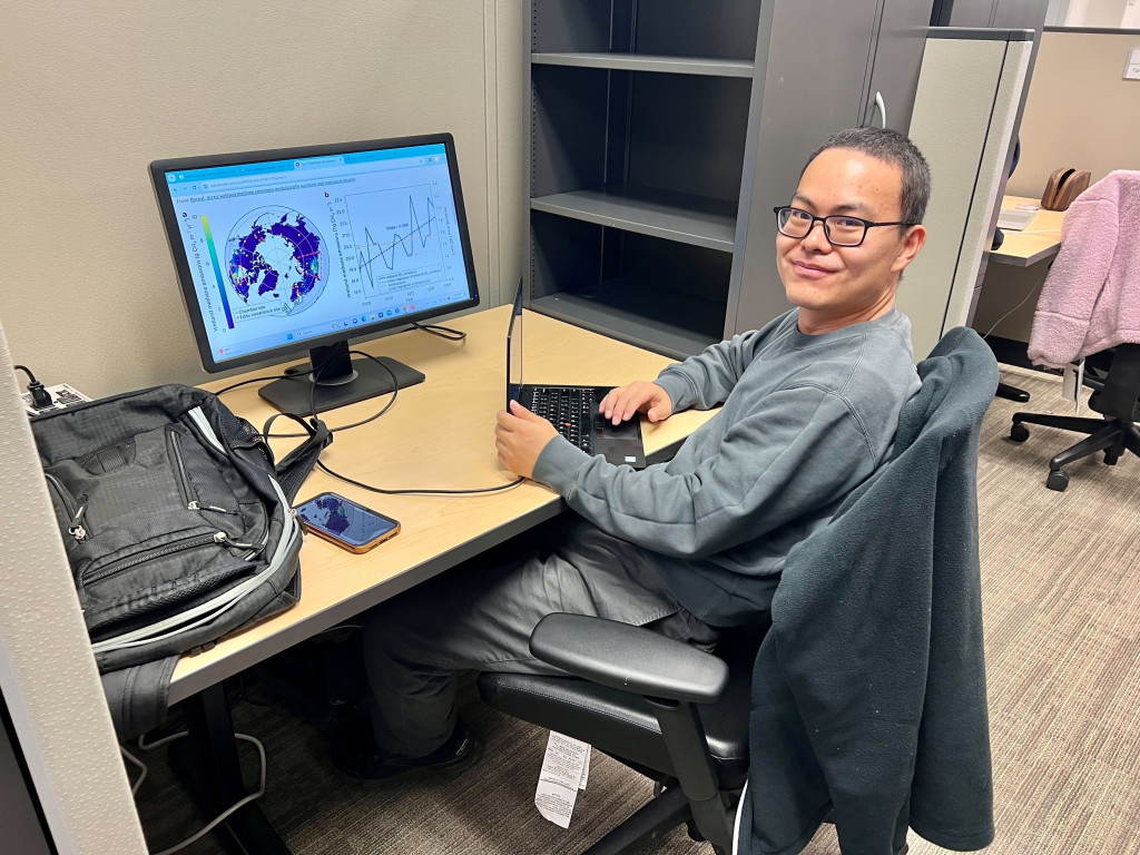 A man sits at a computer working.