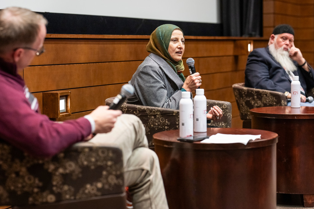 Bibi Bahrami holds a microphone as she speaks to the audience.