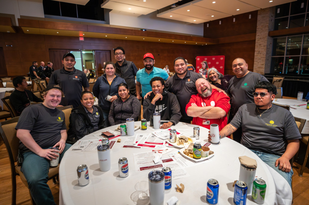 A group of people sitting at a table pose.