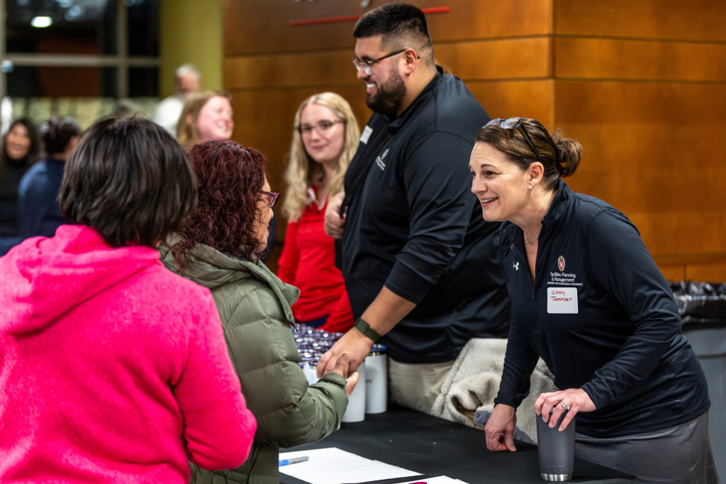 A person talks and shakes hand with others in a line.