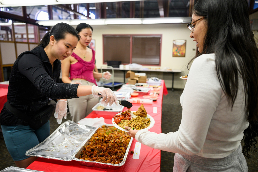 A woman serves food to other people.