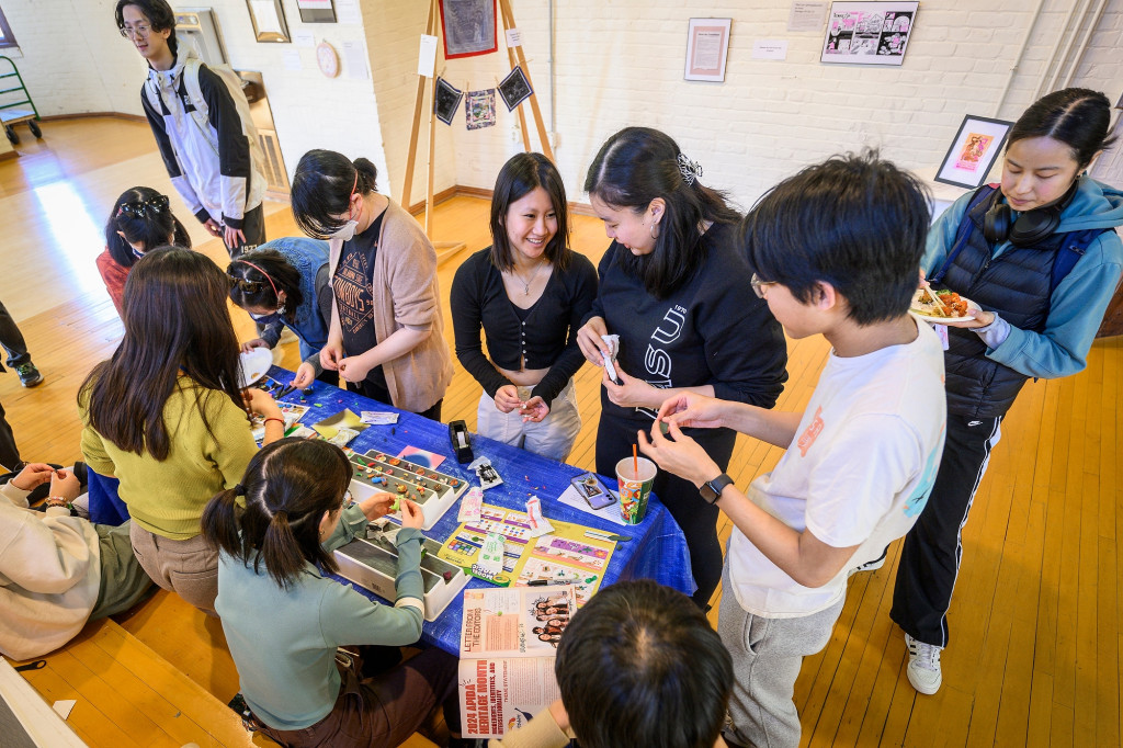 People gather around a table and make art.