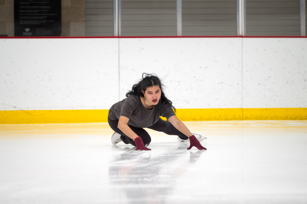 A woman skates on an ice rink.