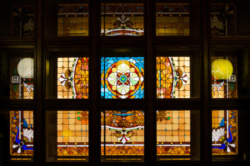 Light streams in through a colorful stained glass window.