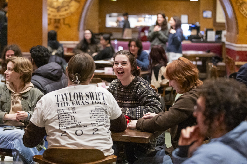 A photo of students sitting around a table, chatting and laughing.