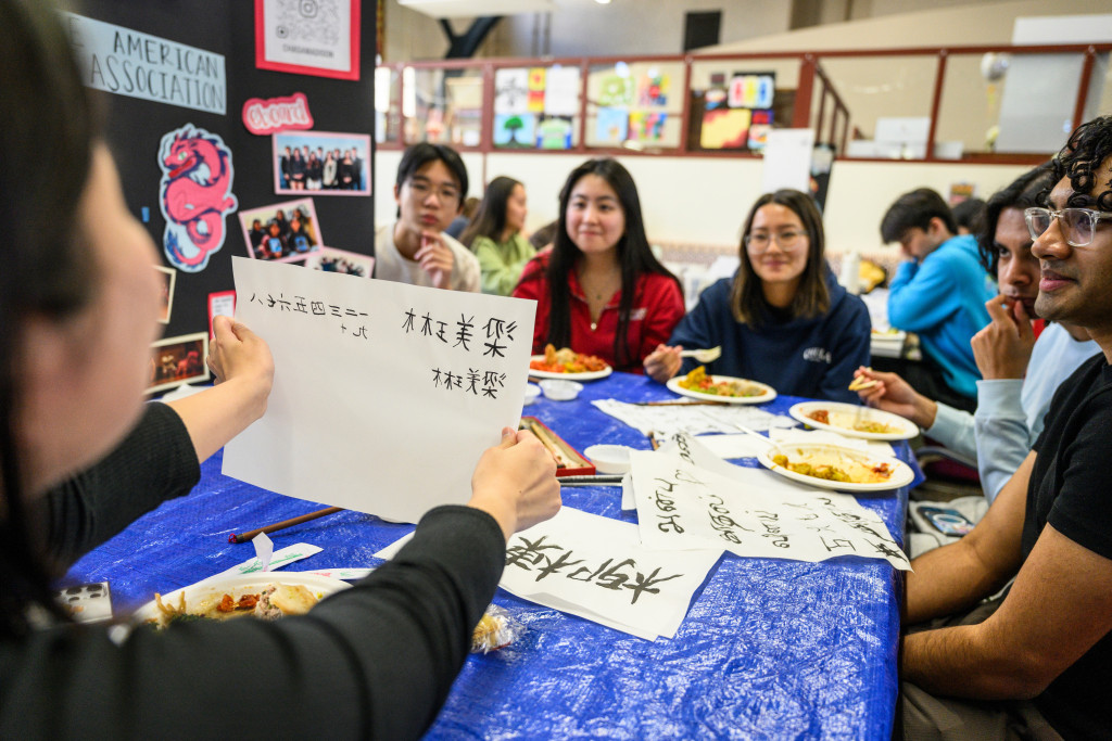 The Asian Pacific Islander Desi American Heritage Festival on April 6 kicked off the month’s events with street-style food and engaging activities from across APIDA cultures. Above, undergraduate Sam Leong shows friends their calligraphy at the Chinese American Student Association (CHASA) table during the Asian Pacific Islander Desi American (APIDA) Heritage Festival.