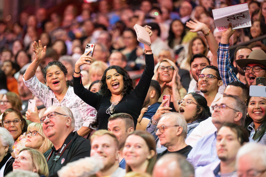 A photo of family members sitting the audience laughing and cheering.