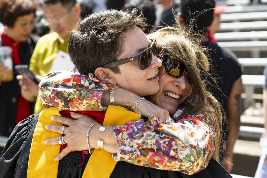 Photo of a man and a woman embracing; someone takes their photo.