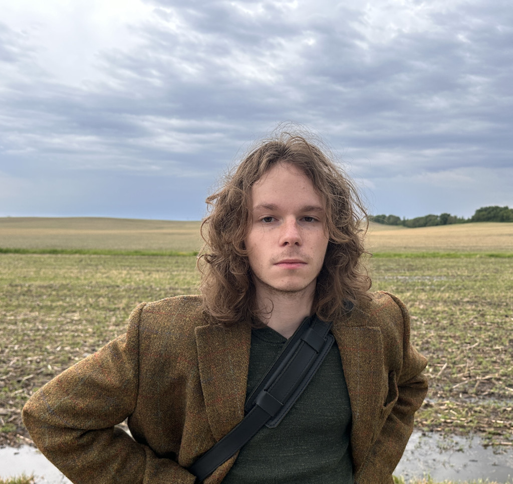 A portrait style photo of Axell Boomer standing outdoors and looking to the camera.