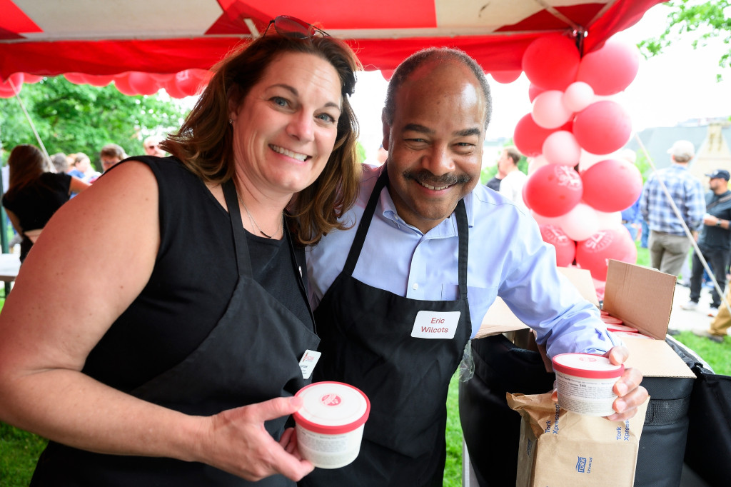 Two people hold ice cream and smile for the camera.