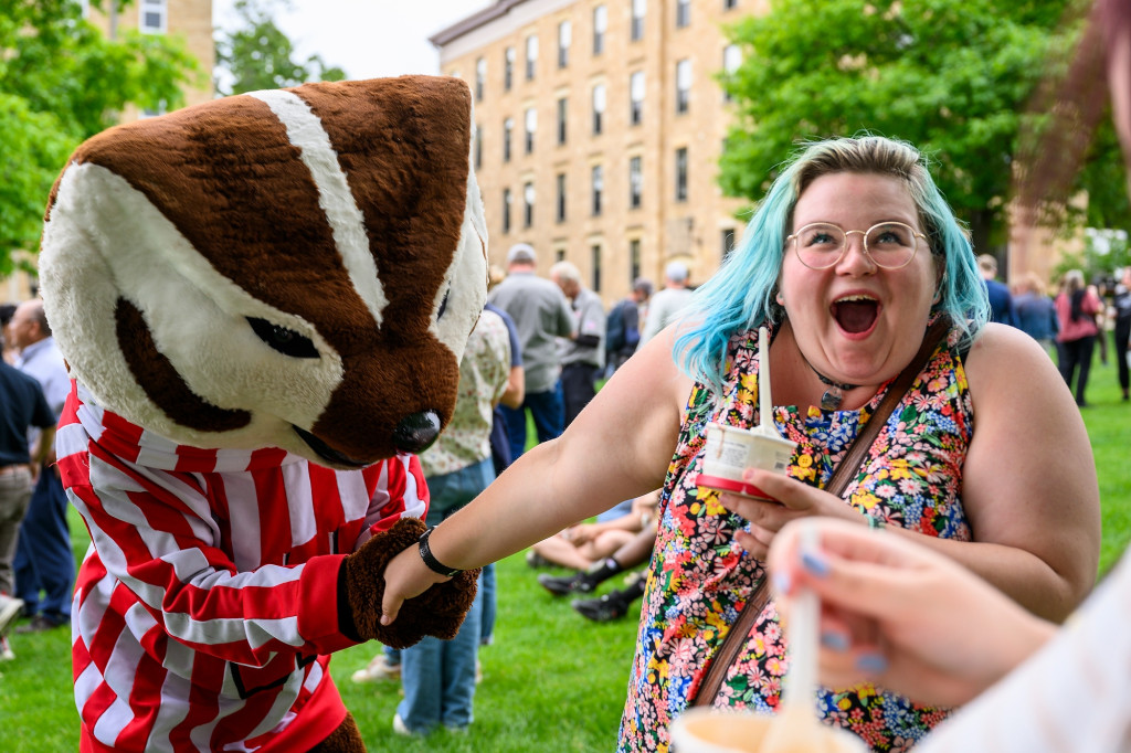 Molly Moen, assistant to the chair of psychology, looks delighted as Bucky Badger kisses her hand.