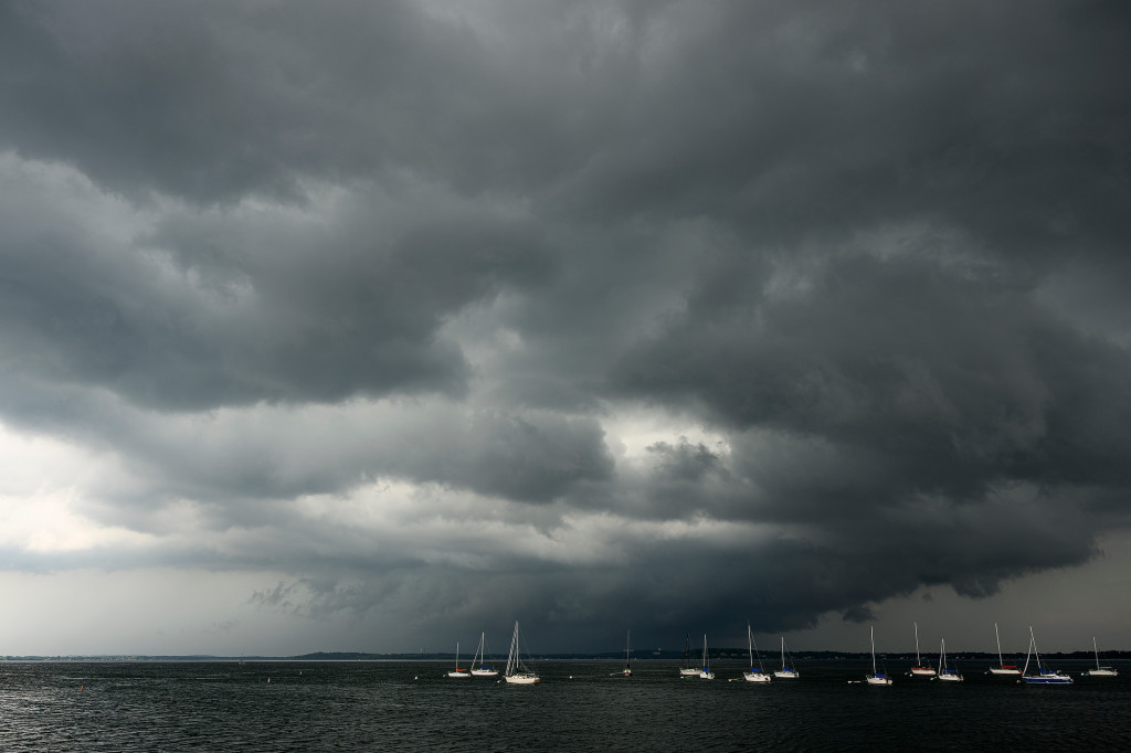 Storm clouds linger over a gray lake.