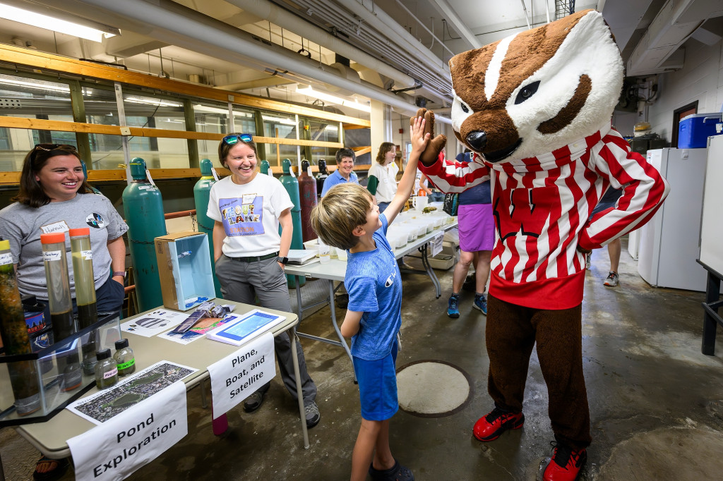 A child high-fives the mascot Bucky Badger.