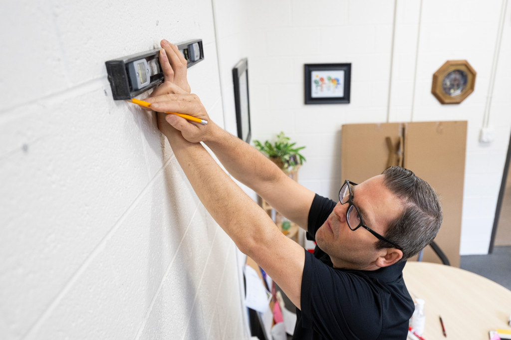 A man measures a wall.