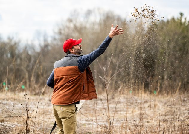 A man throws seeds in the air.