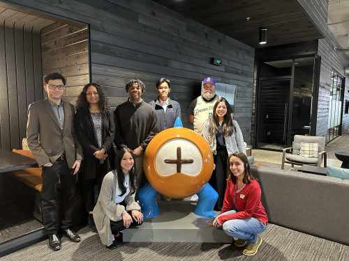 A group of students stand and kneel together to pose for the camera.