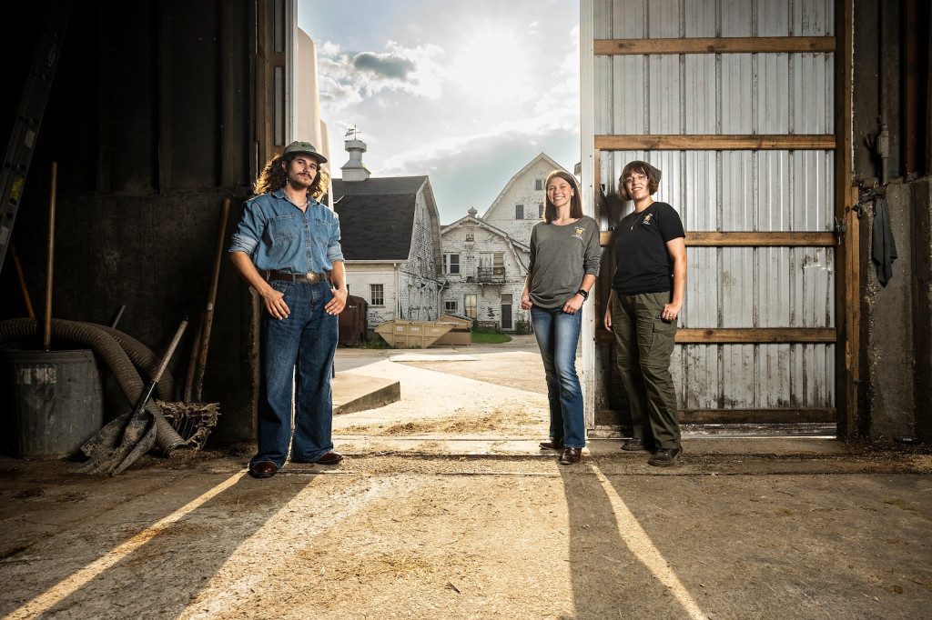 Photo of three people lounging in a barn.