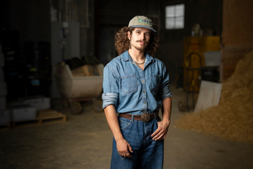 A man stands in a barn.