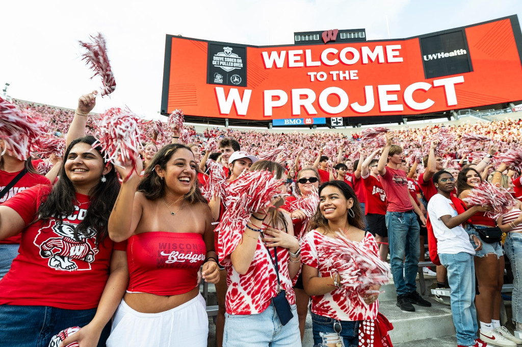 Students gather with red pompoms and sing.