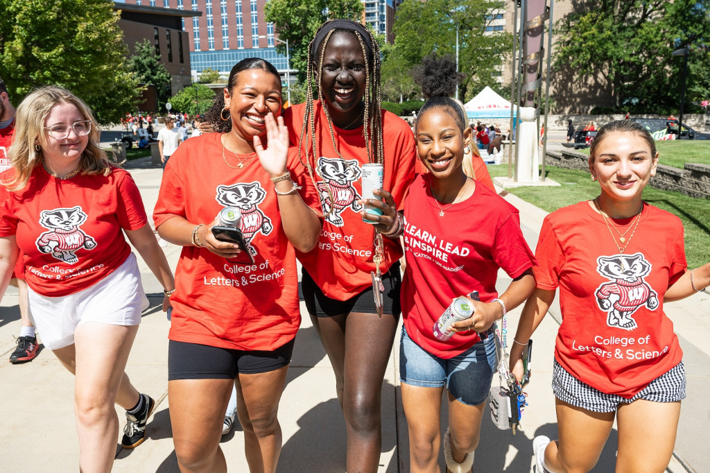 Students wearing Badger t-shirts walk in a group, smiling.