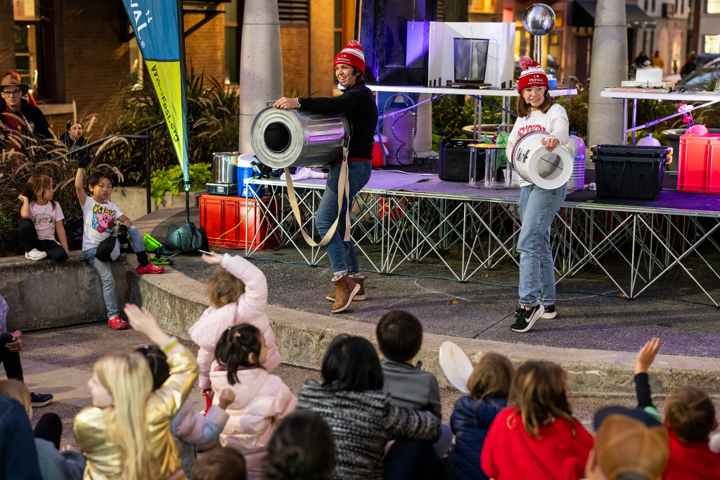 Two women discharge air cannons on a stage.