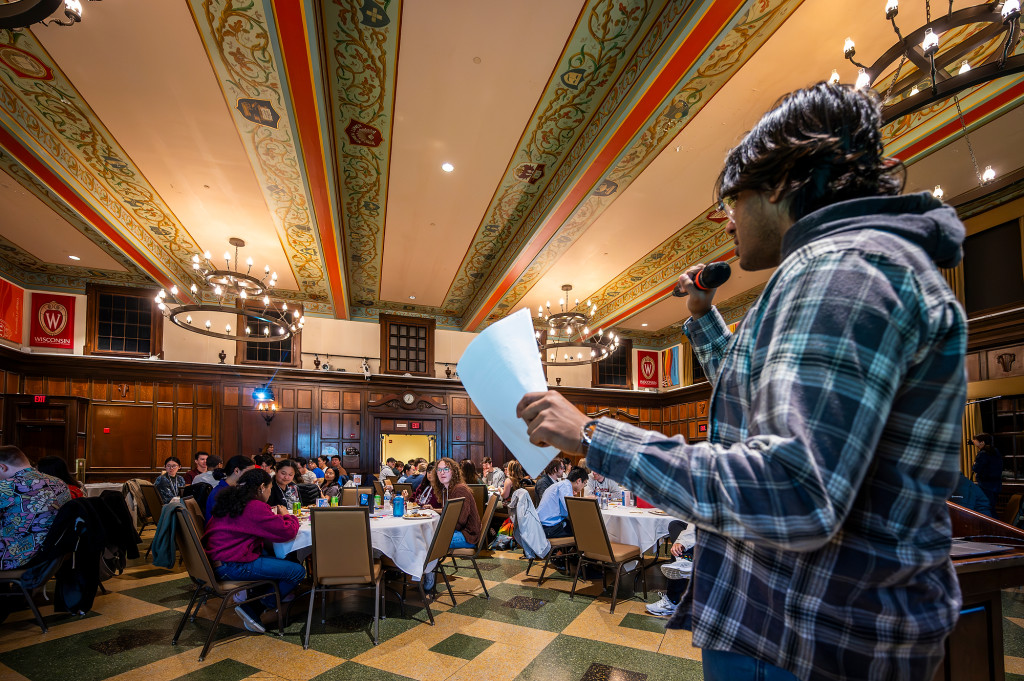 A man addresses a ballroom full of people.