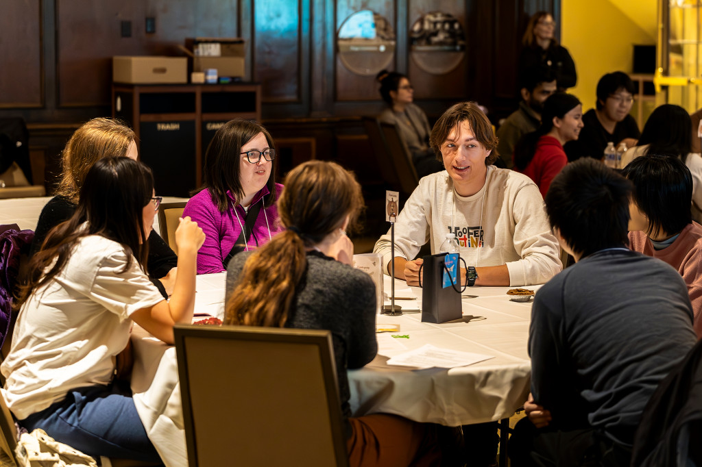 People sitting around a table eat and talk.