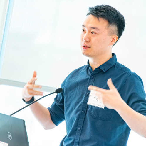 A man speaking at a podium gestures.