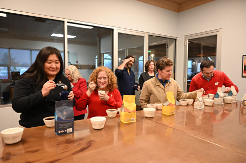 People sit around a table sipping coffee.