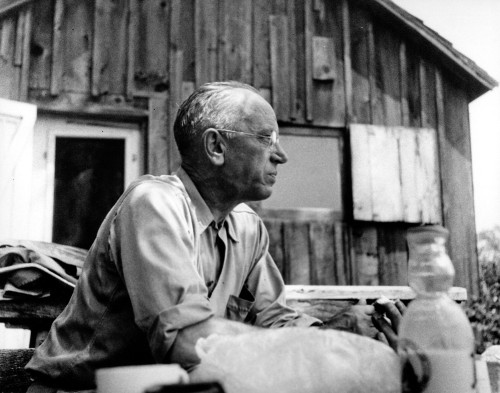 A man sits at a desk and writes.