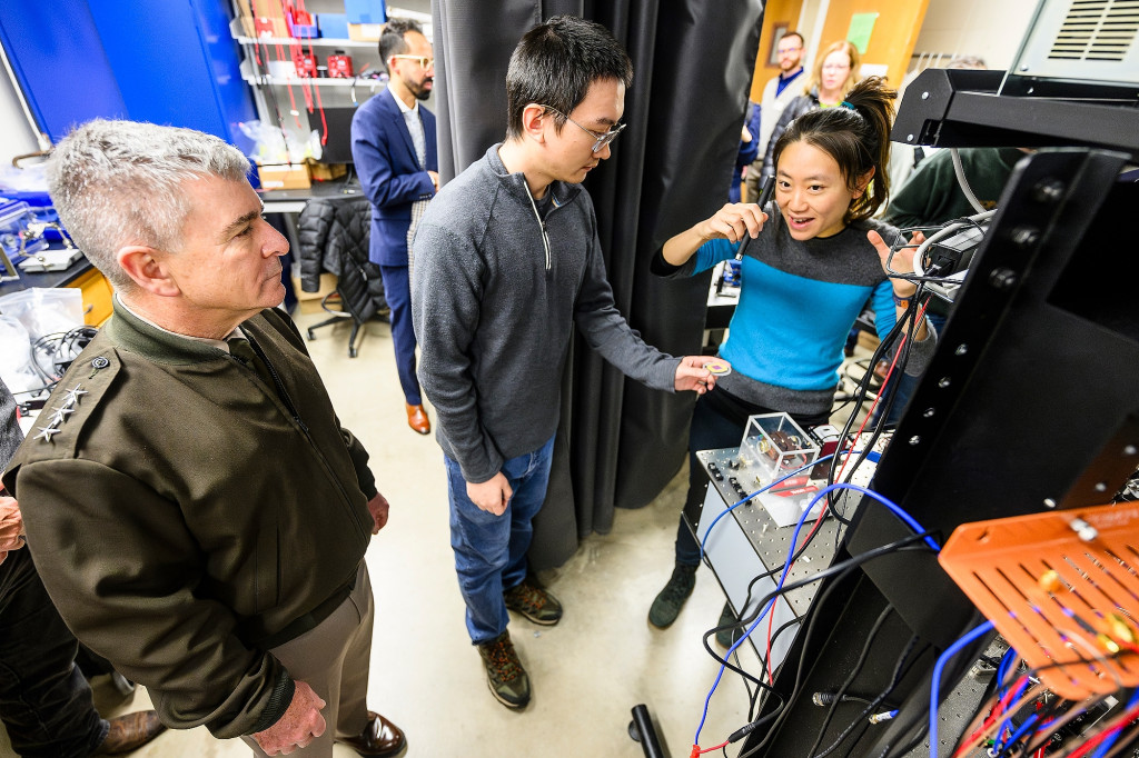 Two people stand together and run some equipment.