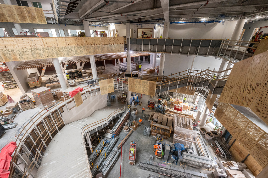 A man leads a tour through a partially constructed building.